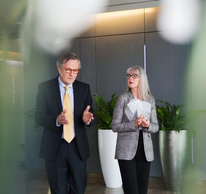 businessman-and-businesswoman-having-discussion-while-walking-e1655275657455.jpg